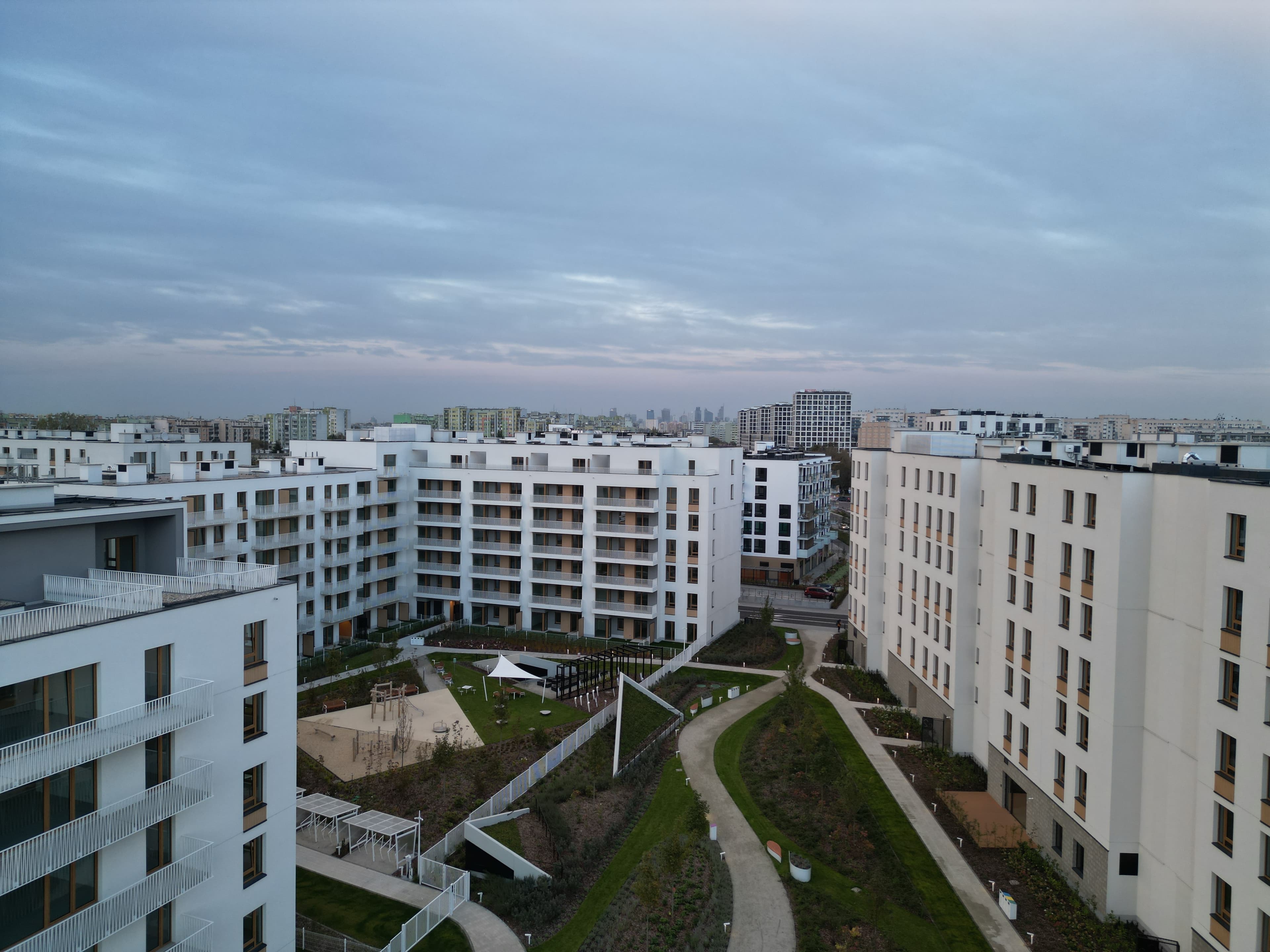 Closer drone view of Neowo rooftops and courtyard landscaping.