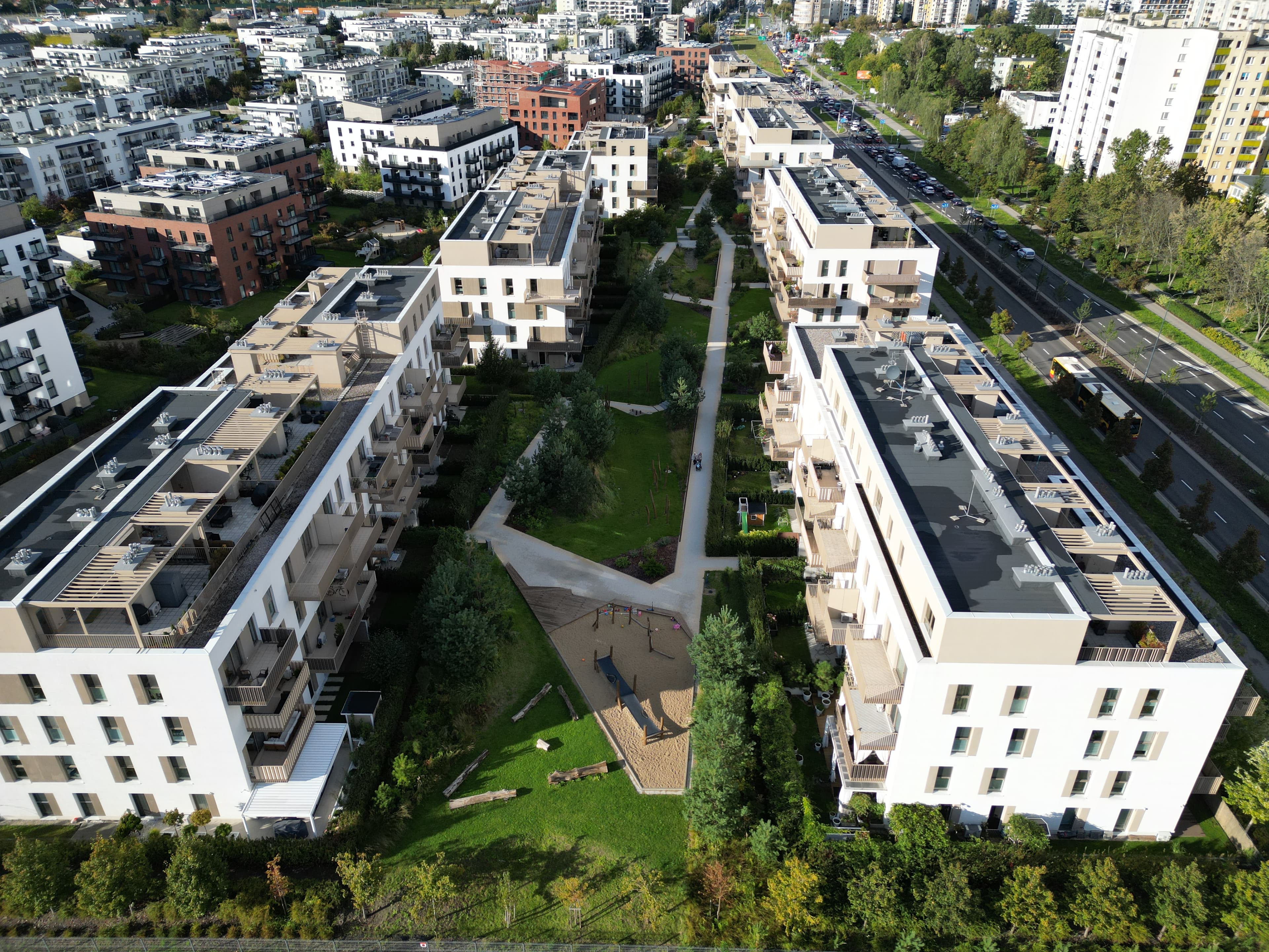Walking through Zielone Bemowo — paths and planted beds between buildings.