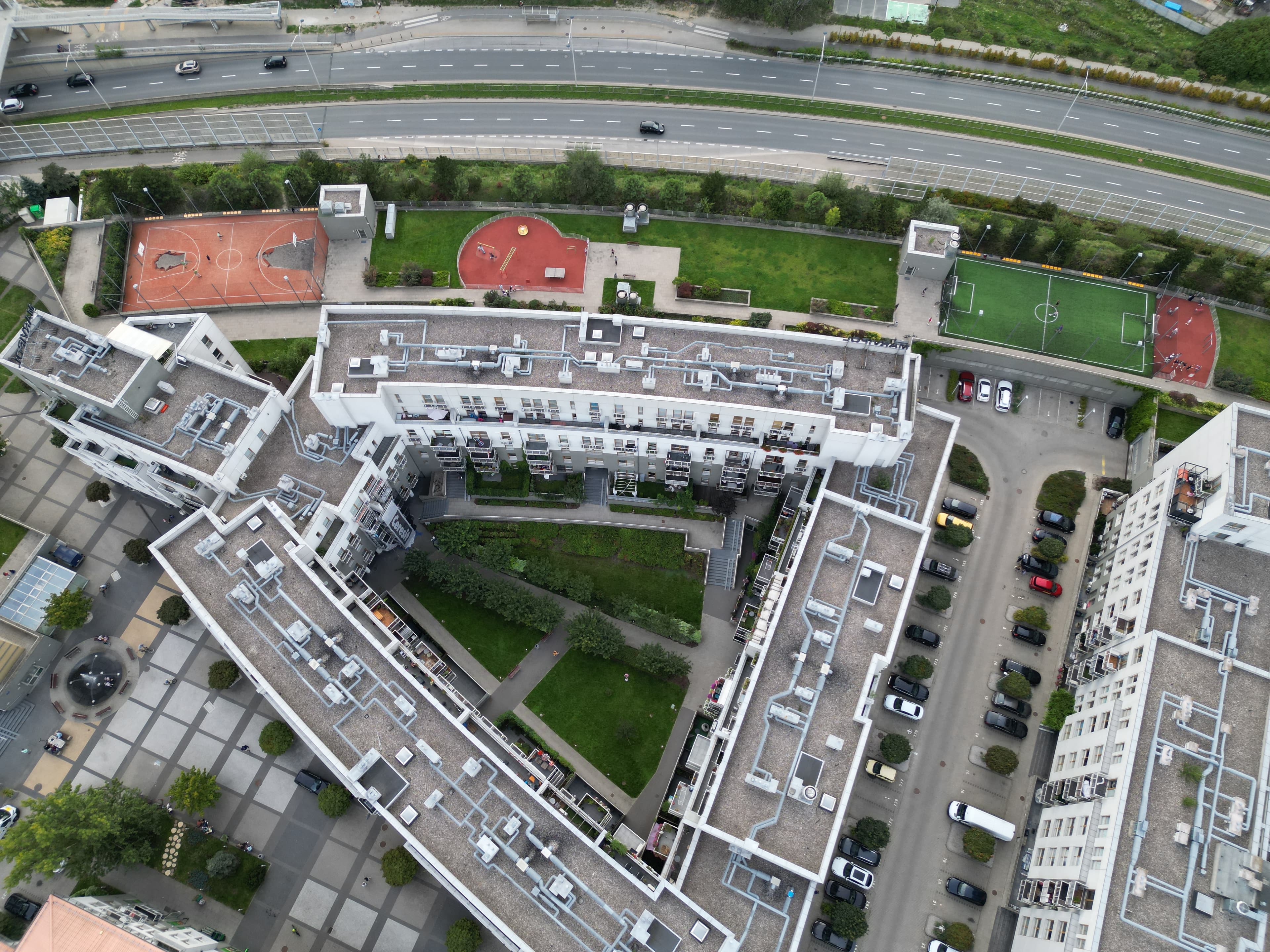 Aerial view of Zielona Italia’s playground, basketball court and football pitch beside the apartment blocks.