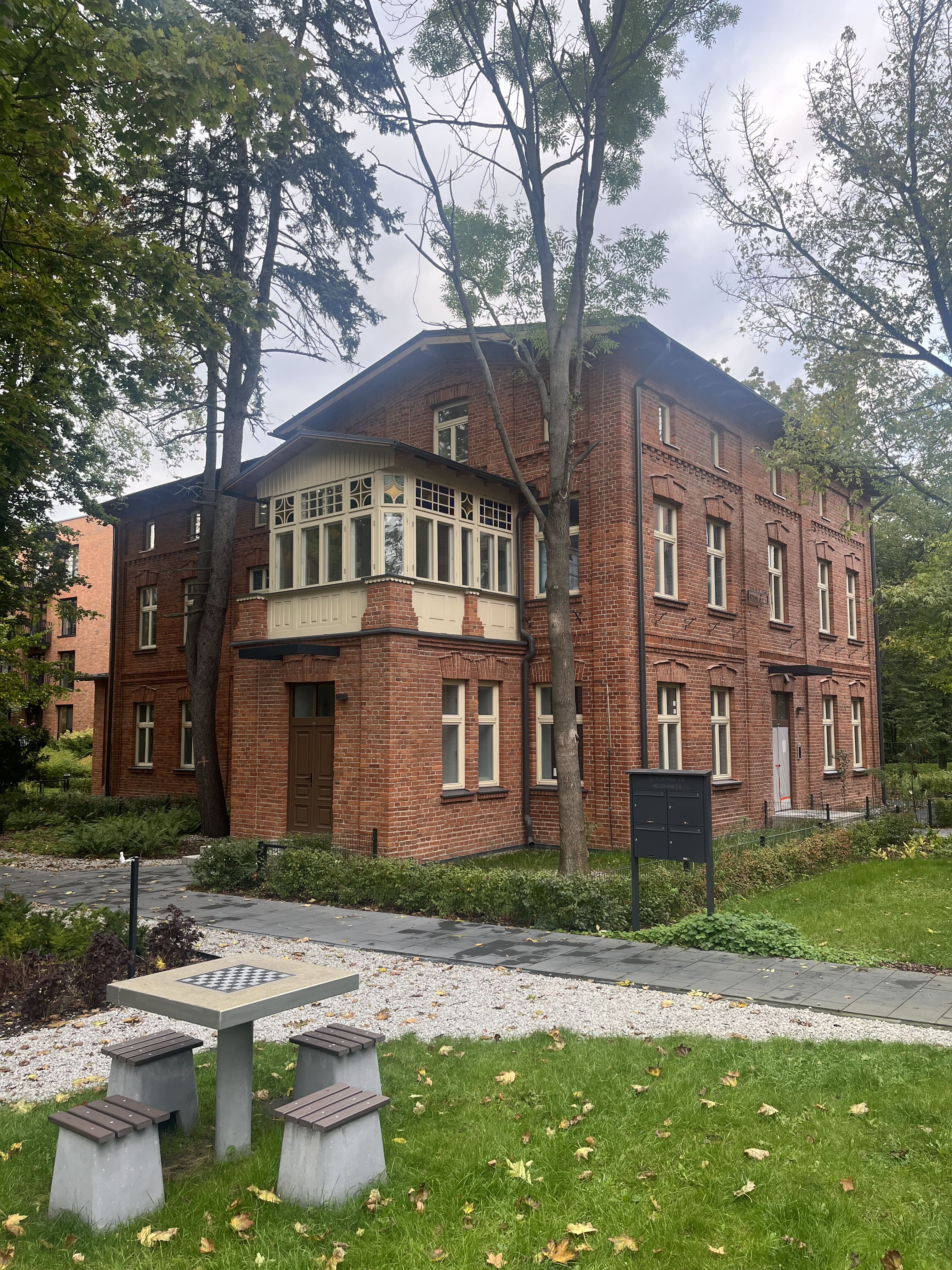Willa Fabrykanta with glass conservatory and courtyard chess table