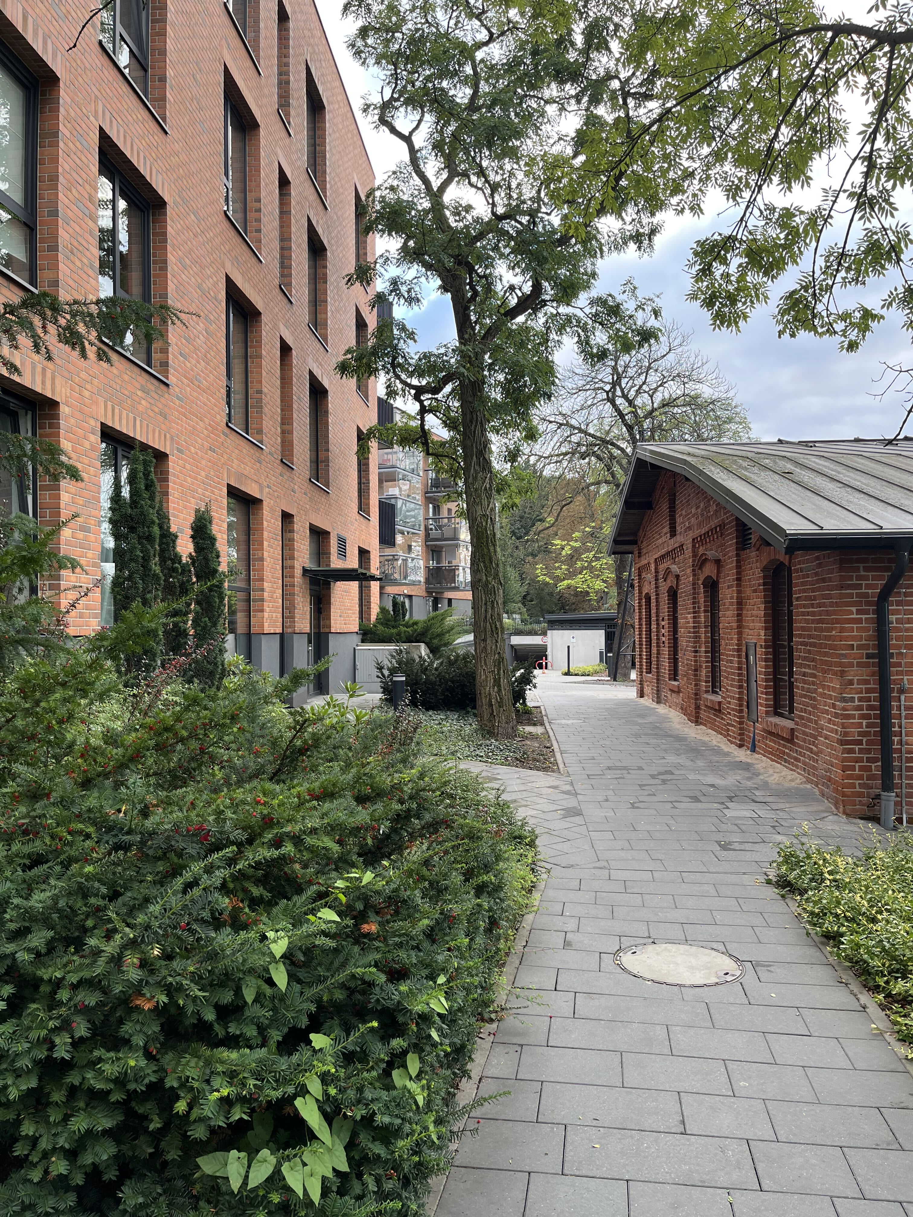 Restored gatehouse beside a new brick block at Aroma Park