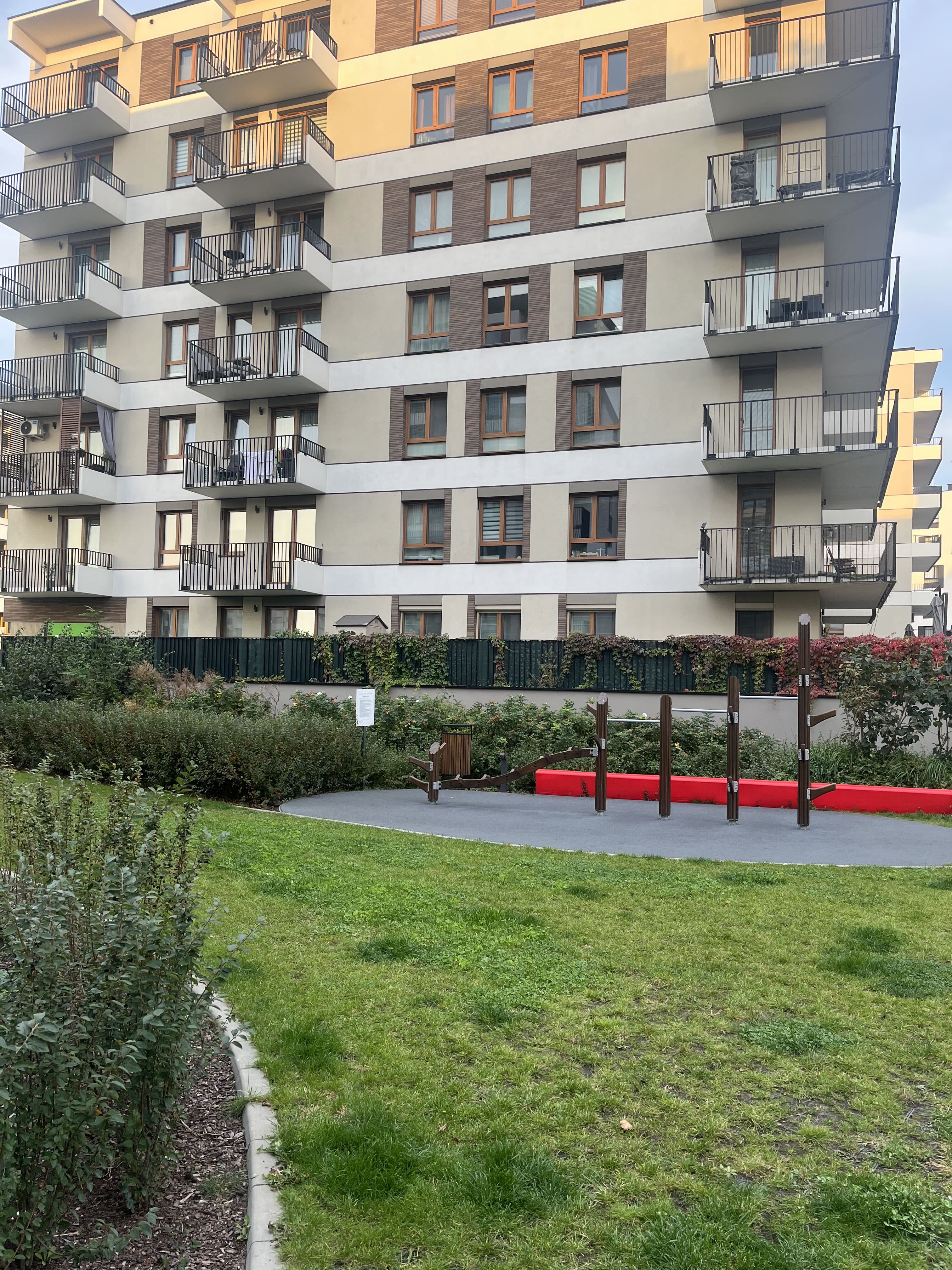 Outdoor fitness area with red bench in front of a Bemosphere building
