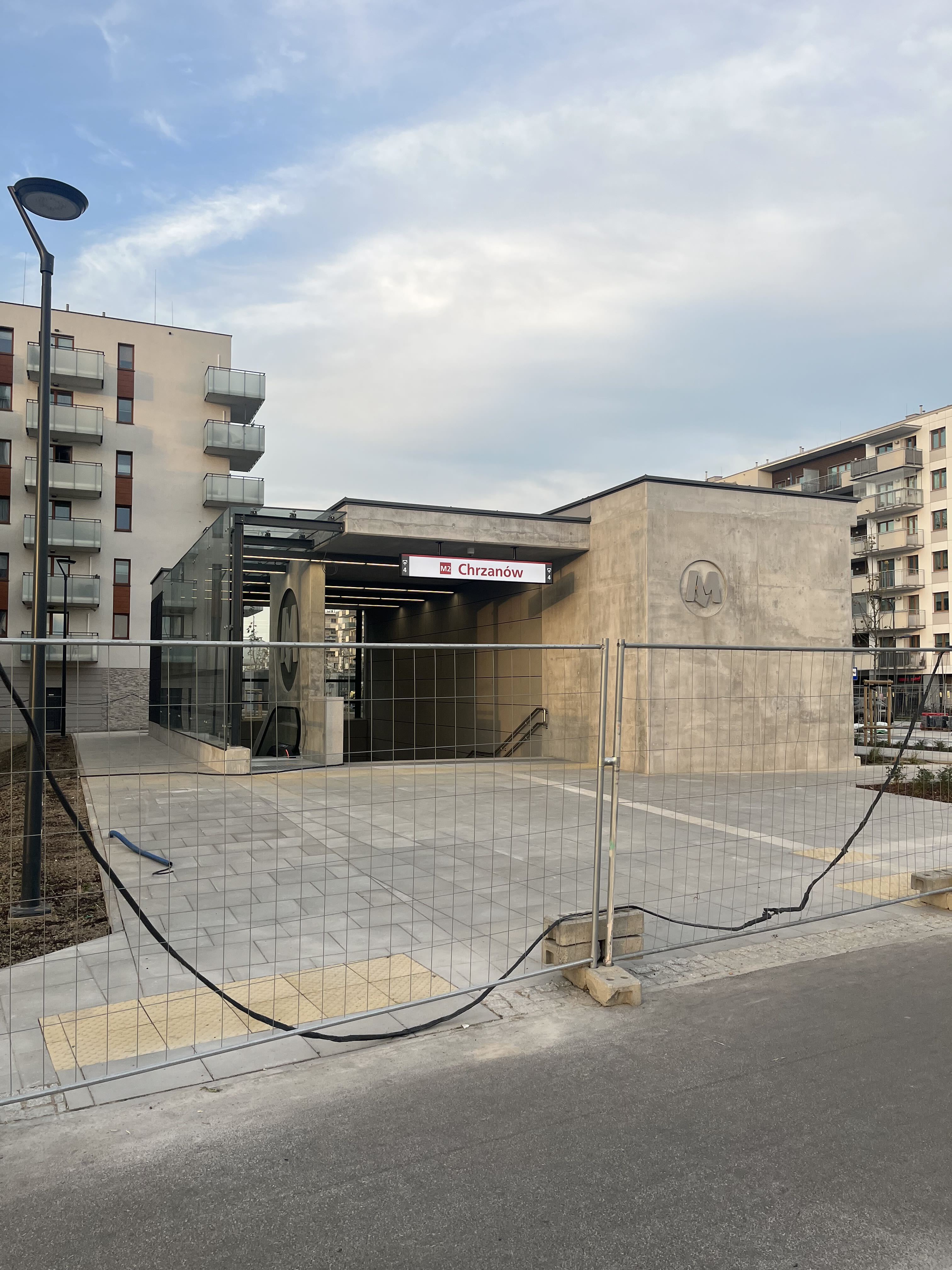 M2 Chrzanów metro entrance pavilion with station sign, still fenced before opening