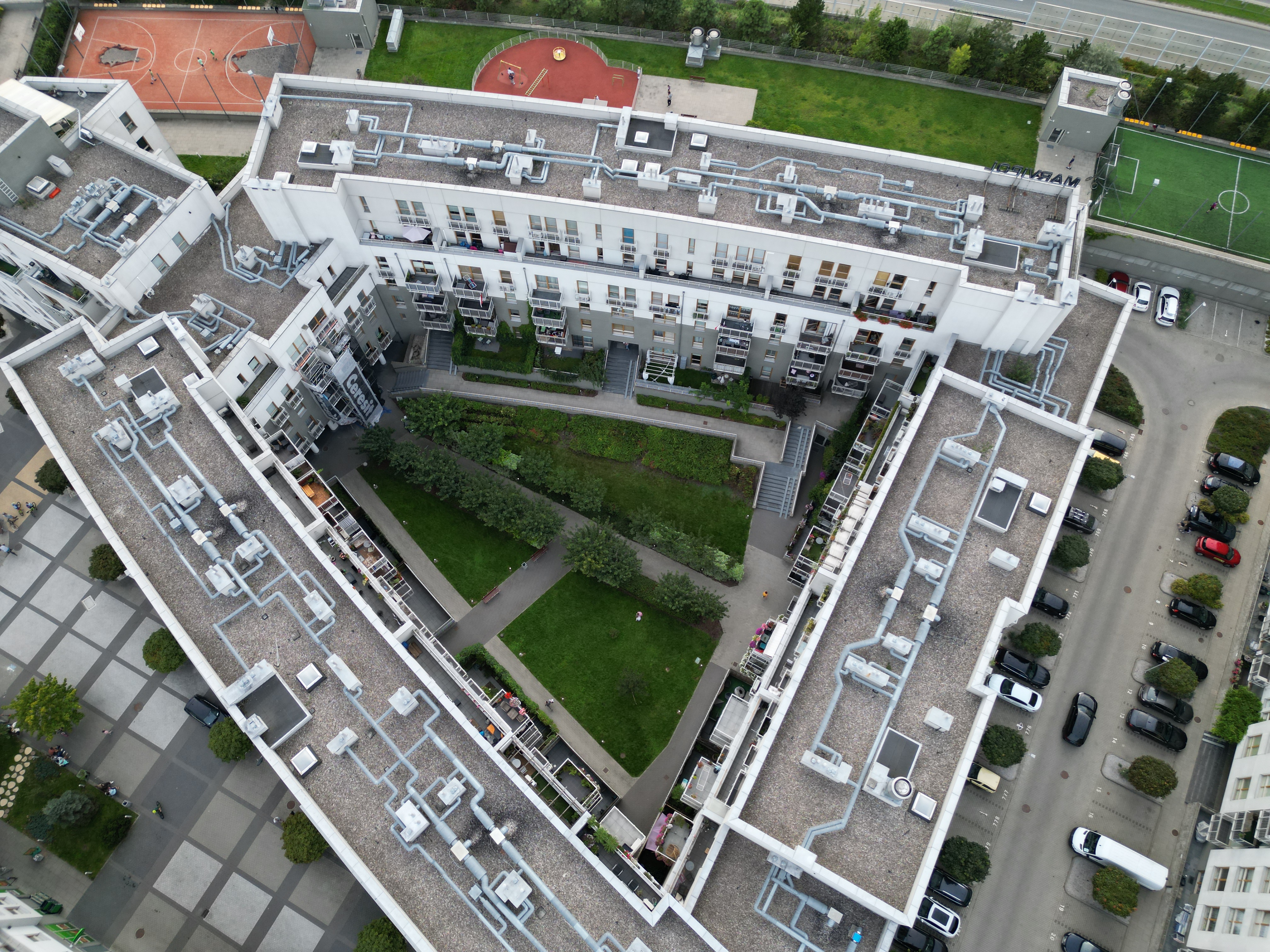 Inner courtyard at Zielona Italia, with terraced lawns, paths and the sports area beyond