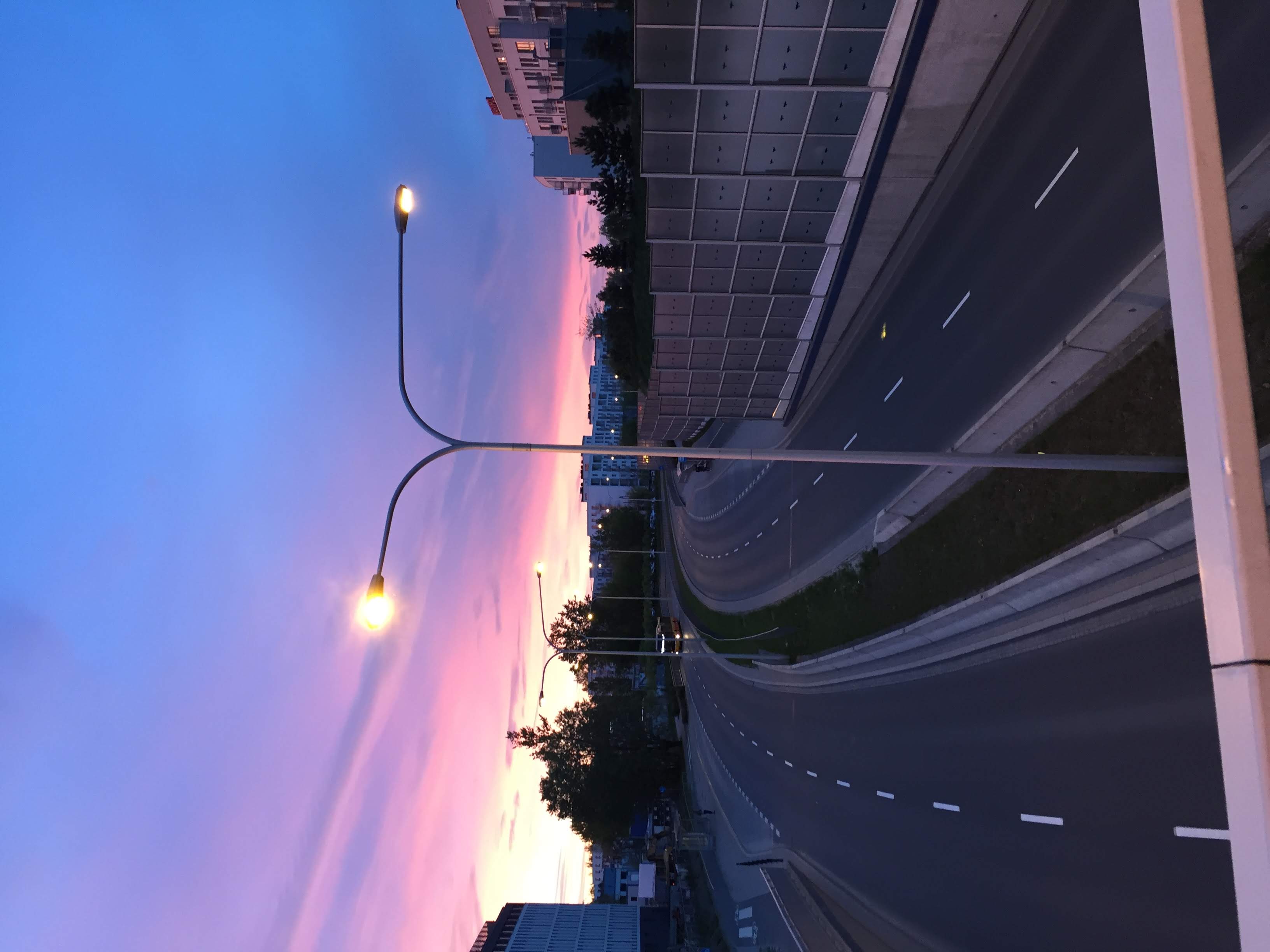 Sunset over Aleja 4 Czerwca next to Zielona Italia, with noise barriers along the road